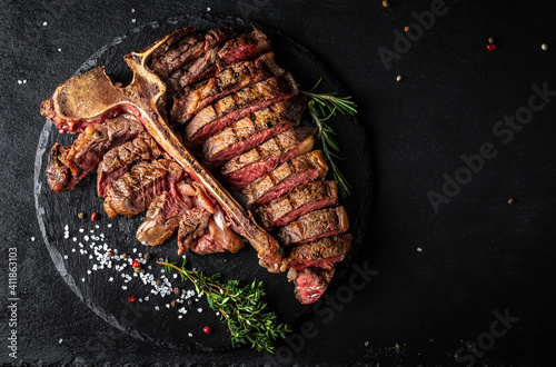 Sliced and roast T-bone or porterhouse beef meat Steak for steakhouse menu on black background. menu recipe place for text, top view