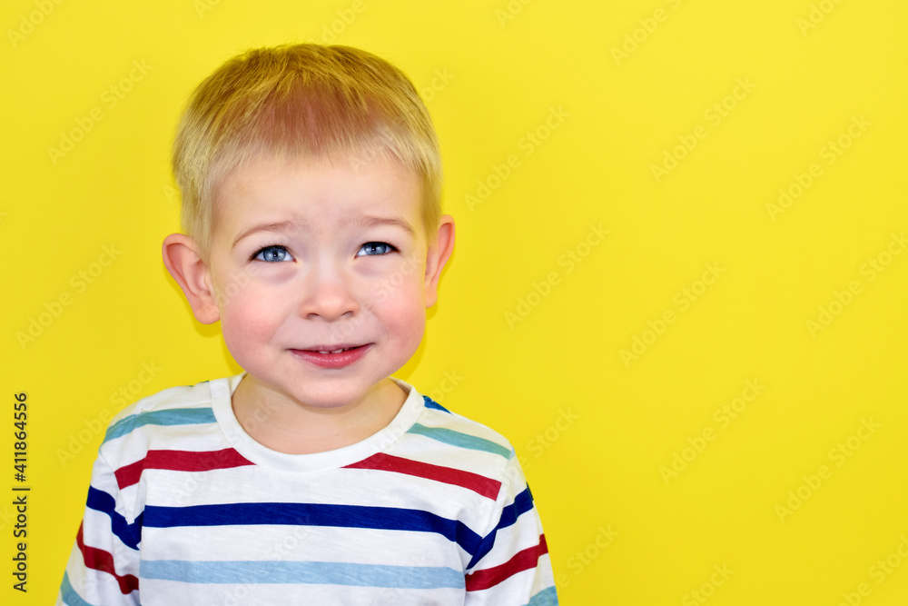 Close up Portrait of a handsome little laughing boy. Adorable small child laughs on yellow background. Cute kid smiling and laughing. Illumination pantone Background. Looking Up. Close up Portrait of a handsome little laughing boy. Adorable small child laughs on yellow background. Cute kid smiling and laughing. Illumination pantone Background. Looking Up.