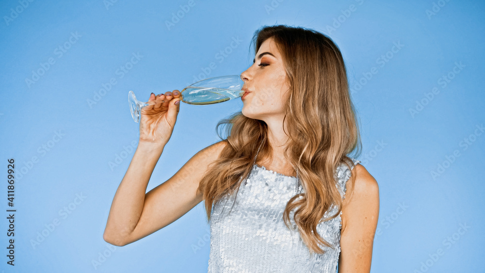 woman with curly hair drinking champagne isolated on blue woman with curly hair drinking champagne isolated on blue