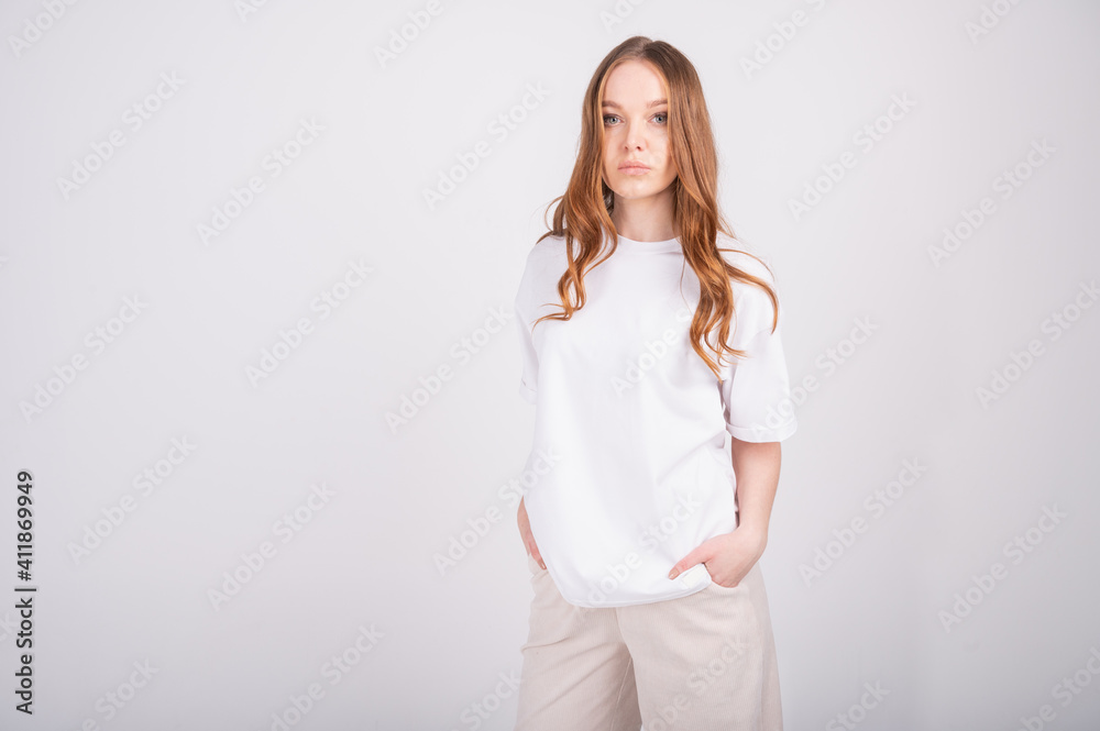 Young beautiful redhead woman in basic clothes. Attractive woman posing on white background. Capsule spring wardrobe concept. Young beautiful redhead woman in basic clothes. Attractive woman posing on white background. Capsule spring wardrobe concept.