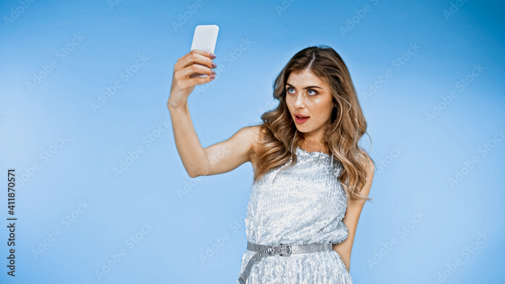 woman with wavy hair taking selfie on blue woman with wavy hair taking selfie on blue