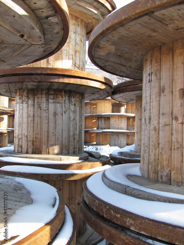 Piles of wood reels covered by snow