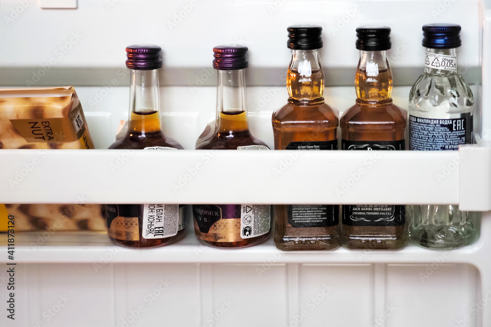 Foto Stock Moscow, Russia - January, 2021: Open minibar at the hotel. Mini  bottles of whiskey Jack Daniels, cognac Courvoisier, vodka Finlandia.  Chocolate | Adobe Stock