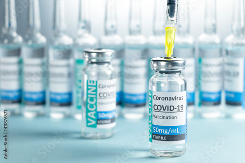 Covid-19 Corona Virus 2019-ncov vaccine vials medicine drug bottles syringe injection blue nitrile surgical gloves. Vaccination, immunization, treatment to cure Covid 19 Corona Virus infection