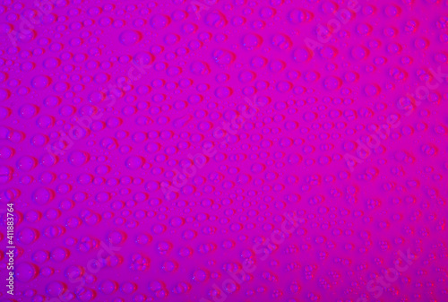 Closeup of water droplets creating a pink color background