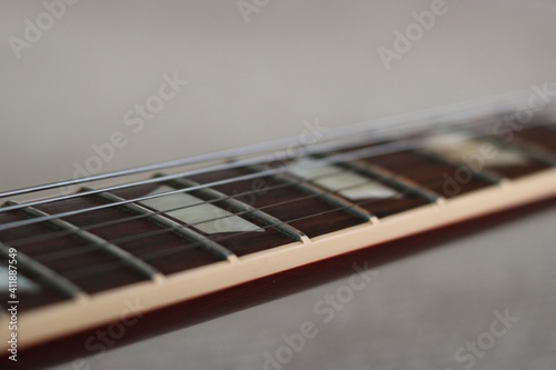 Close up of guitar neck showing fretboard and strings photo
