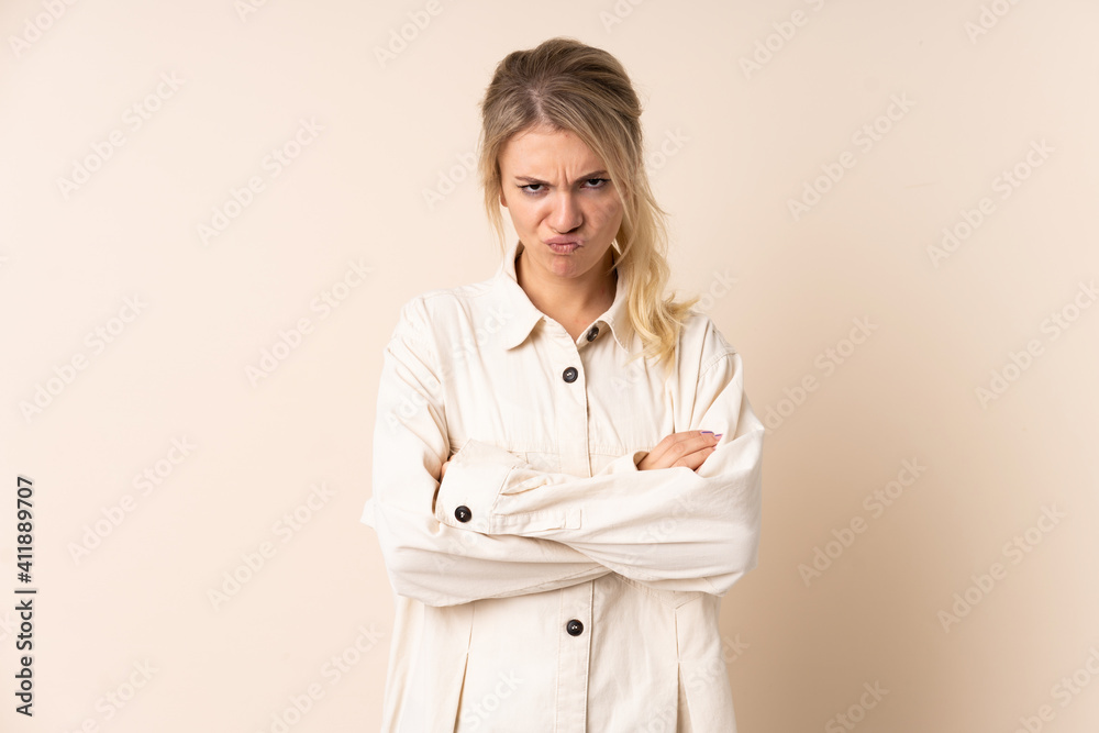 Blonde woman over isolated background with unhappy expression Blonde woman over isolated background with unhappy expression
