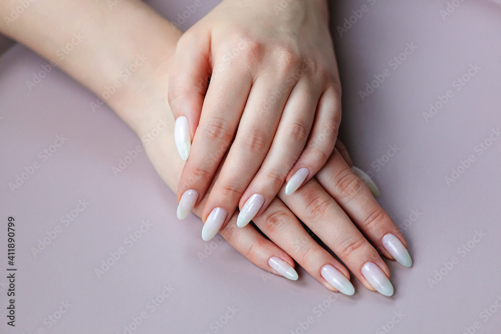 Model woman showing .light white nude shellac manicure on long nails Model woman showing .light white nude shellac manicure on long nails