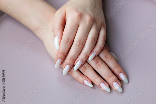 Model woman showing .light white nude shellac manicure on long nails