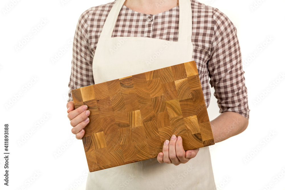 The hands of a culinary man are holding a wooden cutting board.