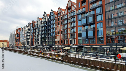 Beautiful colorful townhouses on the banks of the frozen Motlawa River in Gdansk, Poland