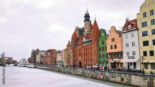 Beautiful colorful townhouses on the banks of the frozen Motlawa River in Gdansk, Poland