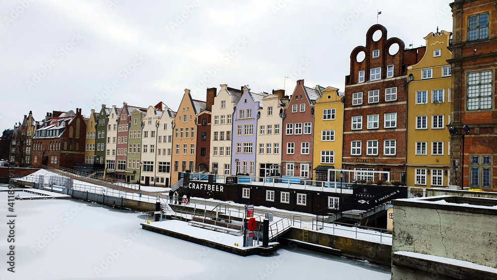 Beautiful colorful townhouses on the banks of the frozen Motlawa River in Gdansk, Poland
