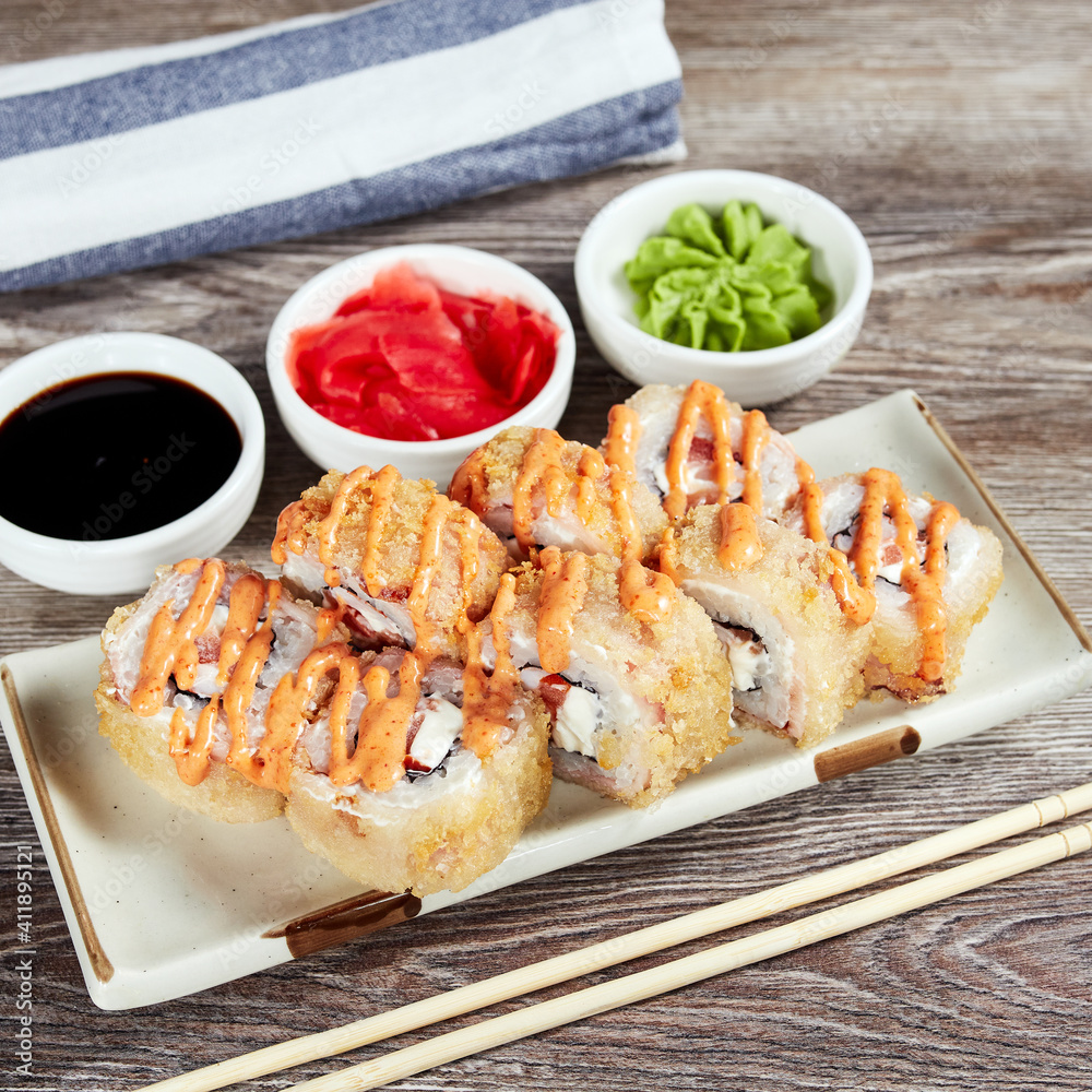 japanese sushi rolls in a rectangular plate on a light wooden table japanese sushi rolls in a rectangular plate on a light wooden table