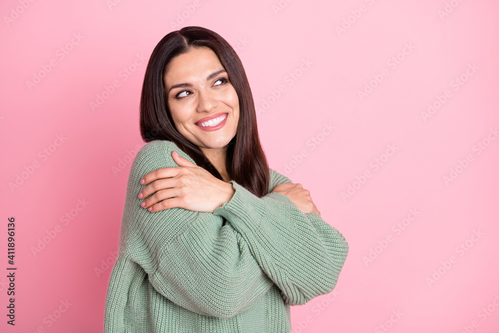 Photo of funny cute girl cuddle herself look empty space wear green cardigan isolated pastel pink color background Photo of funny cute girl cuddle herself look empty space wear green cardigan isolated pastel pink color background