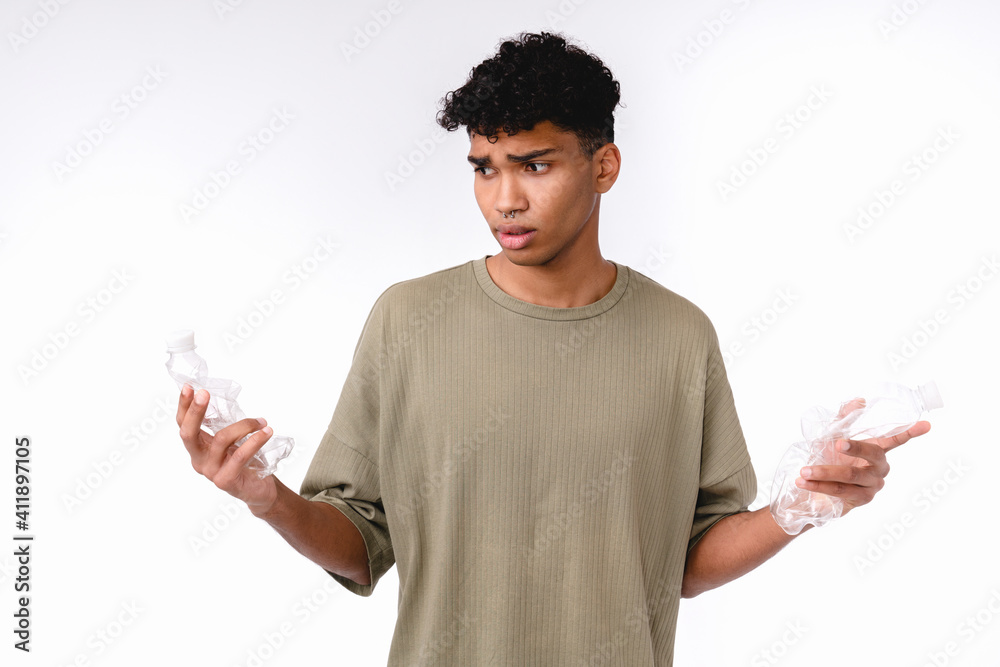 Sad african man holding plastic bottles for recycling isolated over white background Sad african man holding plastic bottles for recycling isolated over white background