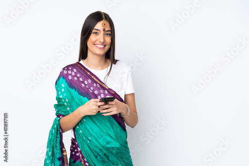 Young Indian woman isolated on white background sending a message with the mobile
