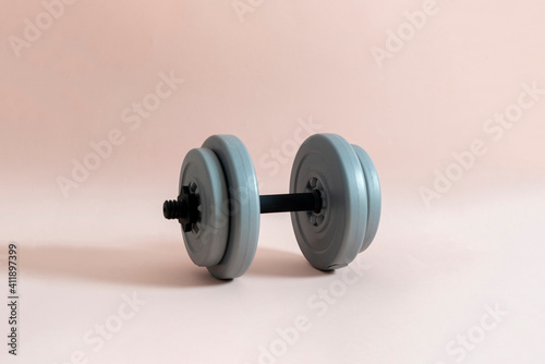 a single grey weight dumbbell, sport body building equipment isolated on the color background
