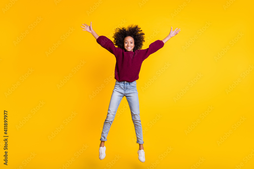 Full length portrait of dark skin pupil jumping show star figure wear pullover isolated on yellow color background Full length portrait of dark skin pupil jumping show star figure wear pullover isolated on yellow color background