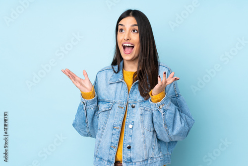 Young caucasian woman isolated on blue background with surprise facial expression