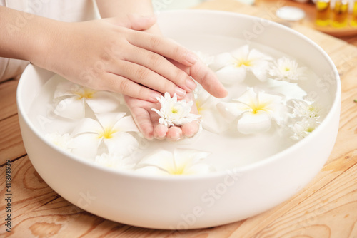 Spa treatment and product for female feet and hand spa. white flowers in ceramic bowl with water for aroma therapy at spa.