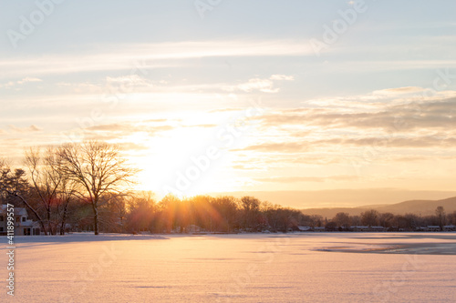 beautiful glowing winter sunset over snow covered lake