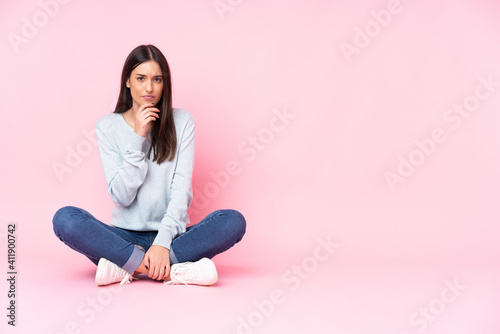 Young caucasian woman isolated on pink background thinking