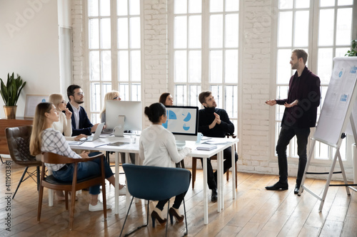 Manager presenting sales report to office colleagues. Leader giving presentation to employees at corporate meeting. Business coach training staff. Workshop, presentation concept