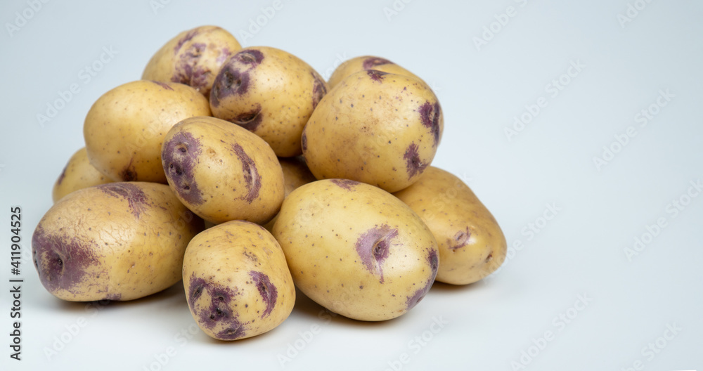 Group fresh raw potatoes on a light background. Group fresh raw potatoes on a light background.