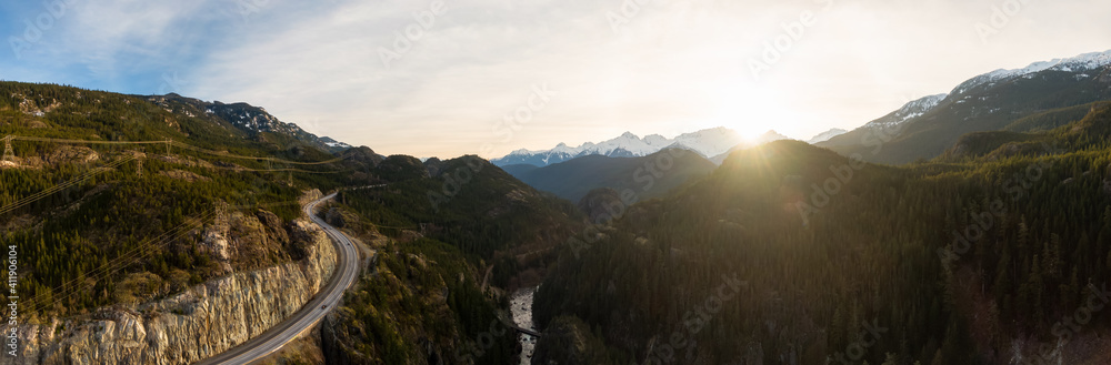 Aerial drone view of Sea to Sky Highway during a bright winter sunset. Taken between Squamish and Whistler, North of Vancouver, British Columbia, Canada.