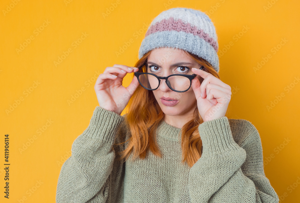 Close-up strict young woman, isolated on yellow background. Jealous pretty girl Close-up strict young woman, isolated on yellow background. Jealous pretty girl