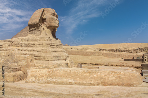 The great Sphinx of Giza in the desert near Cairo. It s a close-up without people. A sunny day with some clouds in the blue sky.