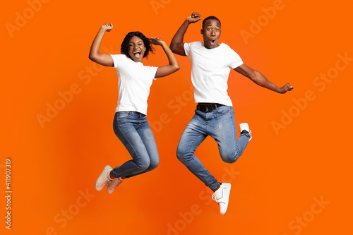 Happy black man and woman celebrating success, full length photo