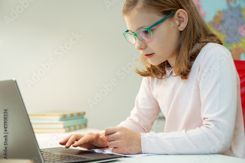 Teen girl in glasses sudy at home at online classroom meeting during pandemic distance homeschooling photo