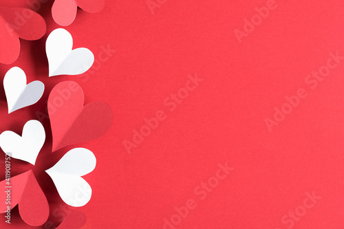 White and red hearts on a red background. The concept of St. Vylentin Day. Festive background. Copy space.