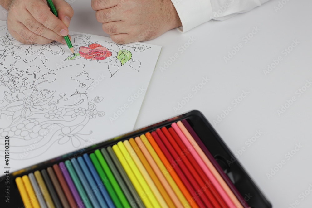 Drawing red rose in mandala antistress with multicoloured pencils during lockdown in quarantine. Drawing red rose in mandala antistress with multicoloured pencils during lockdown in quarantine.