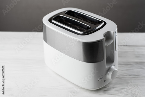White with silver toaster on gray background on wooden white table