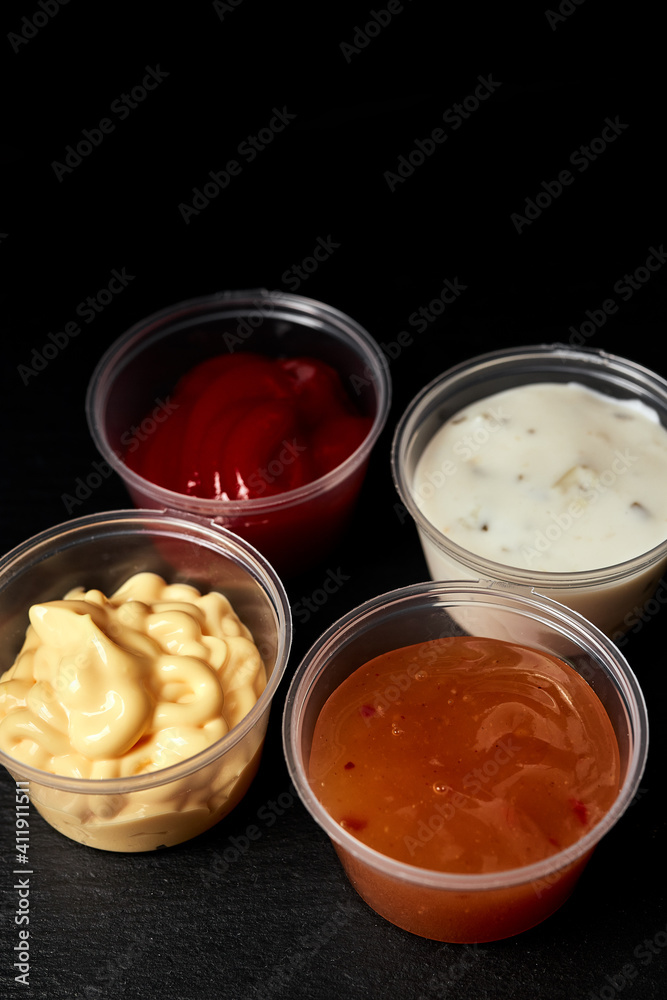 ketchup creamy cheese and sweet and sour sauces on black background ketchup creamy cheese and sweet and sour sauces on black background