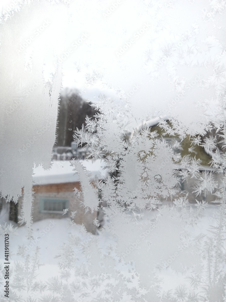 Frost flowers from the ice crystals on the glass of the window. Frost on the glass. Frost flowers from the ice crystals on the glass of the window. Frost on the glass.