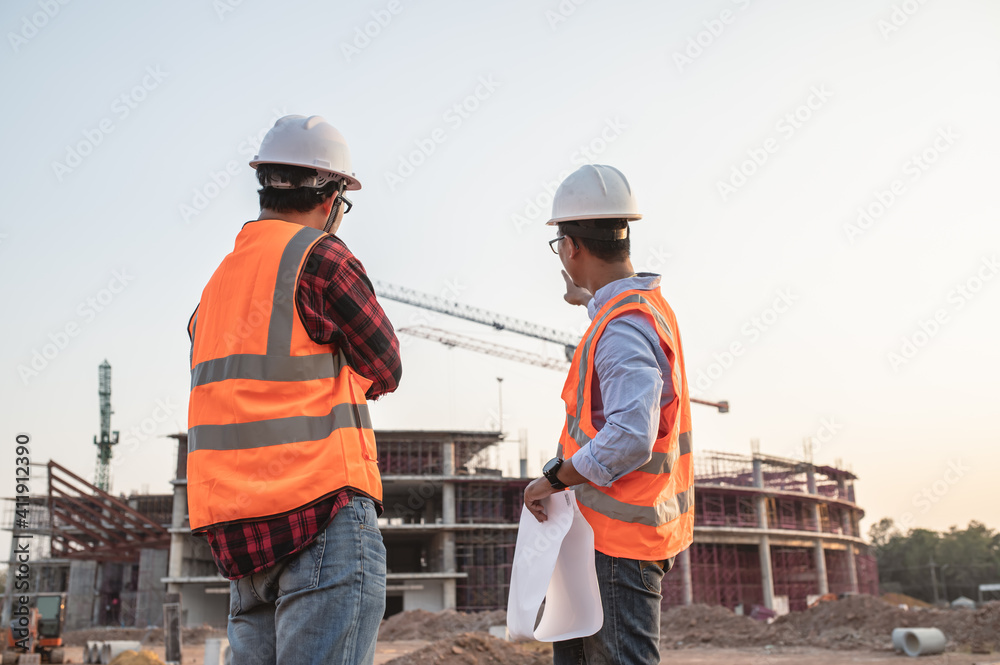 Two Asian engineer working at site of a large building project,Thailand people,Work overtime at construction site,Team of engineer discus at site Two Asian engineer working at site of a large building project,Thailand people,Work overtime at construction site,Team of engineer discus at site