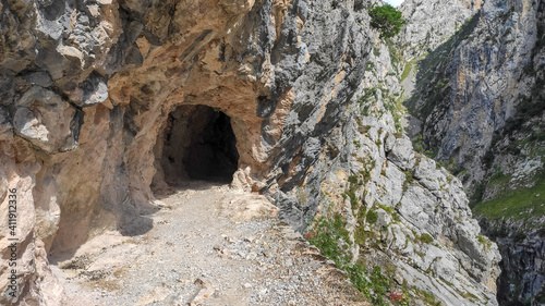 Tunnel pathway in Cares River canyon in Asturias. The Cares Route, placed in the very heart of Picos de Europa National Park, also known as “La Garganta Divina” (The Divine Gorge).