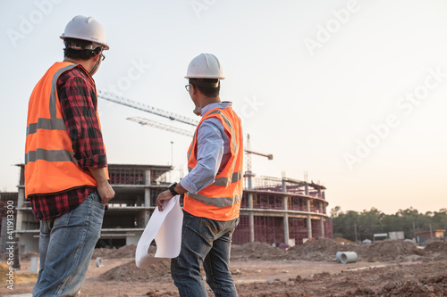 Two Asian engineer working at site of a large building project,Thailand people,Work overtime at construction site,Team of engineer discus at site