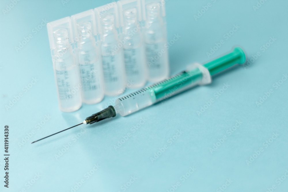 Medical vials for injection, syringe for injection, mask gloves on a blue background. Admission vaccination, flu shot. Medical vials for injection, syringe for injection, mask gloves on a blue background. Admission vaccination, flu shot.