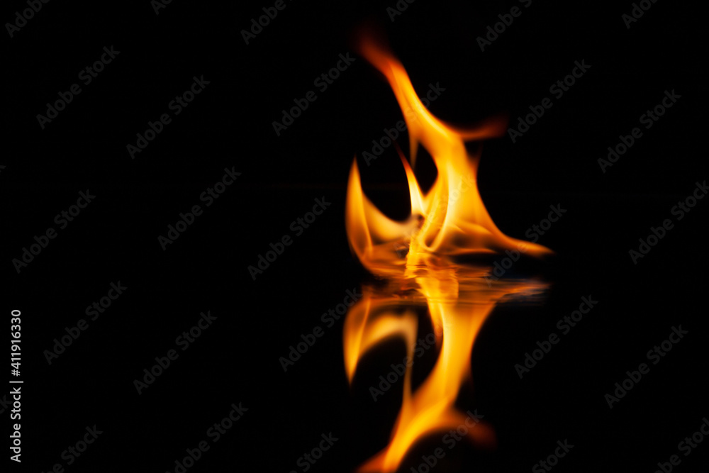 fire flame with reflection in the glass on a black background fire flame with reflection in the glass on a black background
