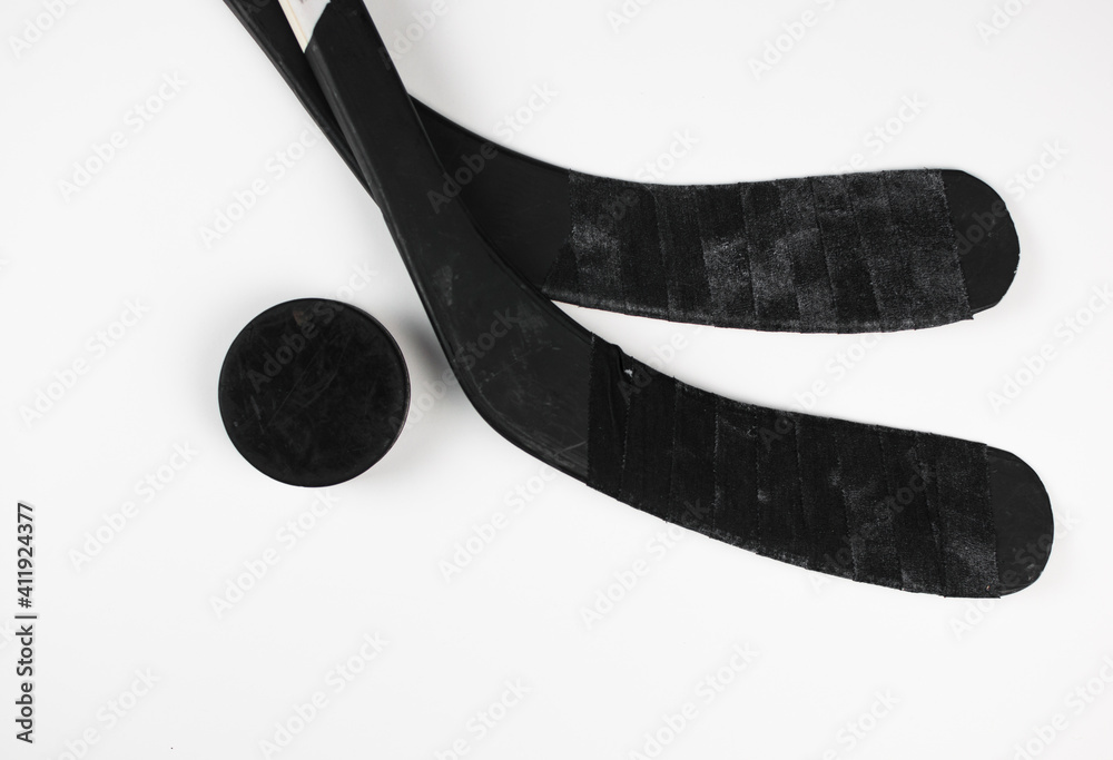 A fragment of a hockey stick and puck on a white background A fragment of a hockey stick and puck on a white background