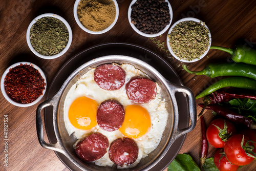 Fried sausage with egg in copper pan turkish meal