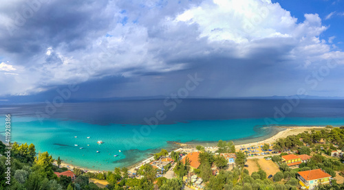 Panoramic shot at Chalkidiki Greece at summer 2020 during pandemic covid-19 nice blue sea and the village of Athitos on the coast, and some clouds in the sky 