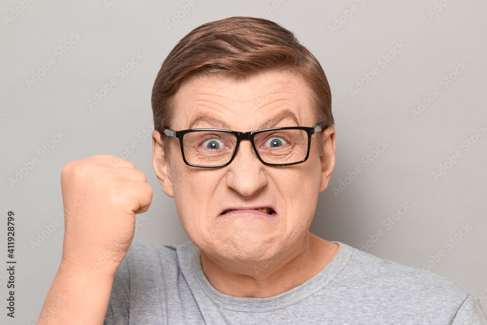 Portrait of angry annoyed man shaking fist in threatening gesture