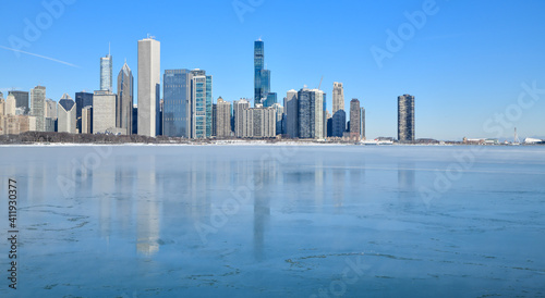 Big city skyline along frozen lakeshore in winter