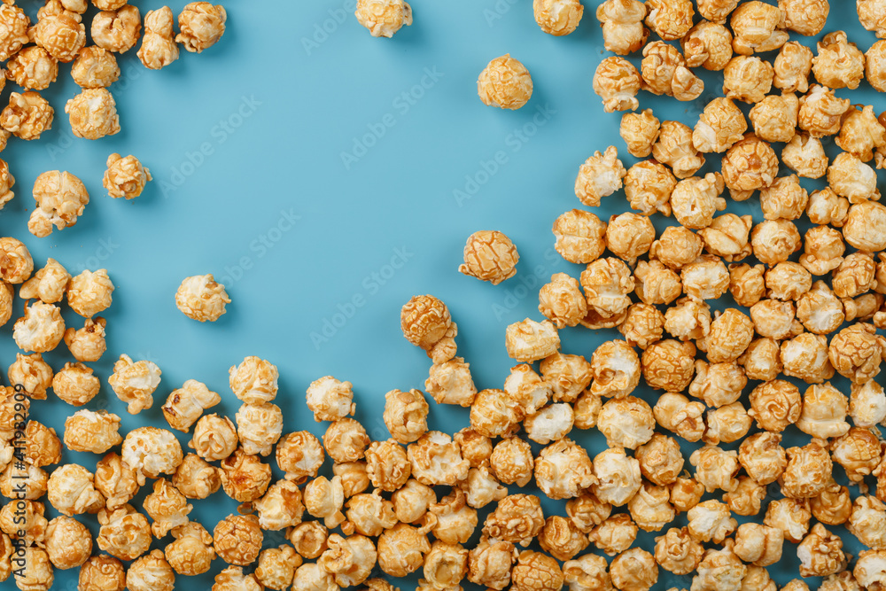 Popcorn is scattered on a blue background, in the form of a frame. Popcorn is scattered on a blue background, in the form of a frame.